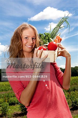 Young woman with vegetables in basket