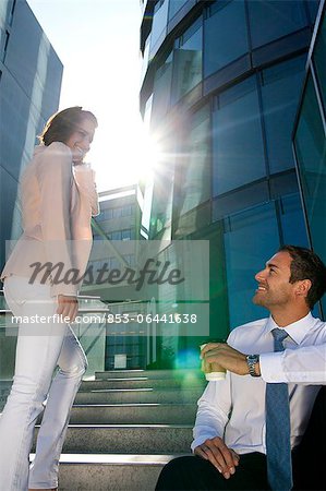 Homme d'affaires souriant et femme d'affaires dans les escaliers