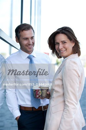 Businessman and businesswoman with coffee to go talking