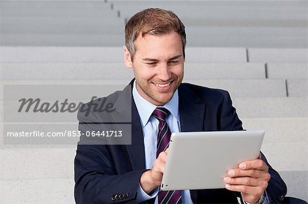 Businessman using tablet PC on stairs