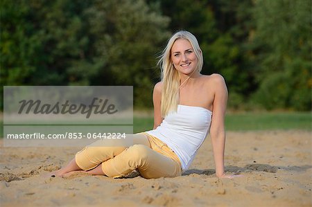 Happy young blond Woman am Sandstrand