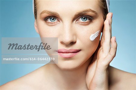 Woman applying moisturiser