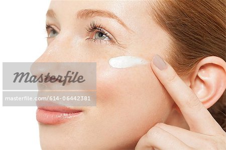 Woman applying moisturiser