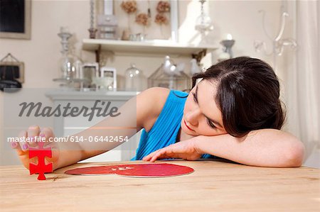 Woman doing heart shaped jigsaw puzzle Woman doing heart shaped jigsaw puzzle