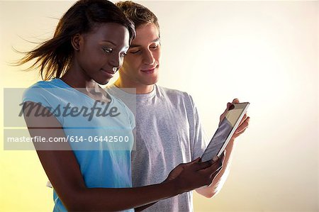 Teenager-Mädchen und jungen Mann betrachten digitaler tablet