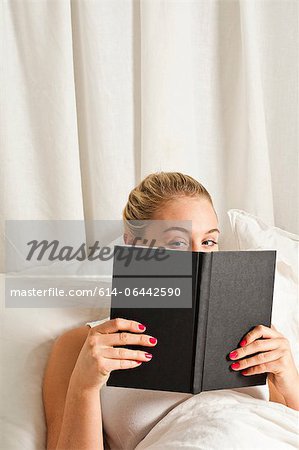 Woman reading book in bed