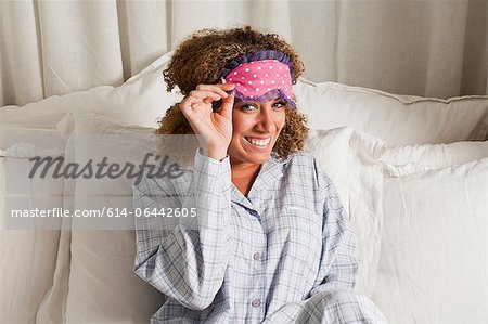 Frau trägt Augenmaske im Bett