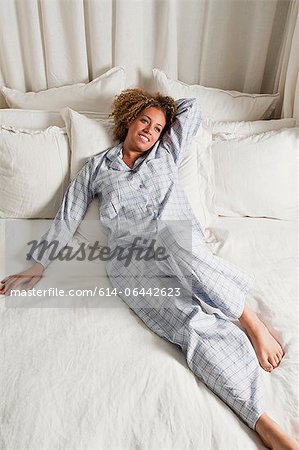 Woman wearing pyjamas reclining in bed