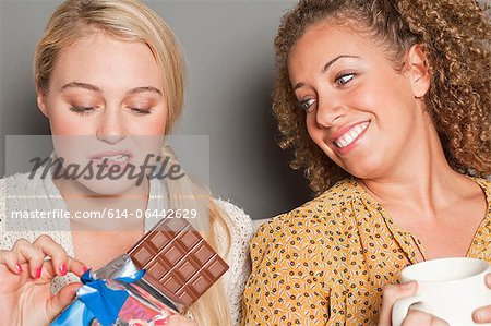 Woman staring at friend holding chocolate