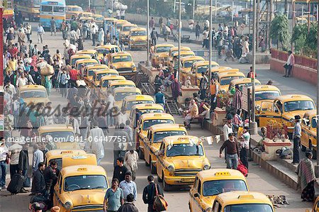 Taxis jaunes de Kolkata et les navetteurs à l'extérieur de la gare de Howrah en heure de pointe de matin, Howrah, Kolkata (Calcutta), West Bengal, Inde, Asie