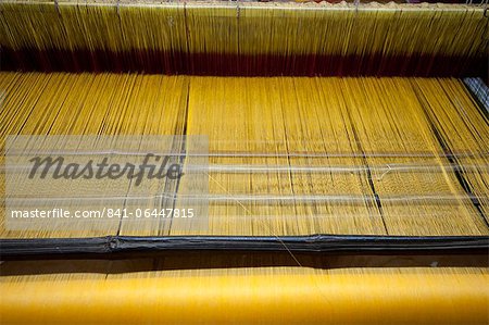 Yellow dyed silk being woven on loom, Naupatana weaving village, rural Orissa, India, Asia