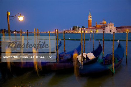 Gondolas moored on the Lagoon, San Giorgio Maggiore beyond, Riva degli Schiavoni at dusk, Venice, UNESCO World Heritage Site, Veneto, Italy, Europe