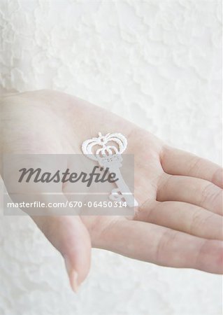 Hand holding key-shaped lace Hand holding key-shaped lace