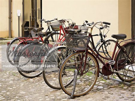 parked bicycles on cobblestone street, Tuscany, Italy
