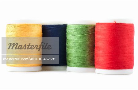 Four spools with green, yellow, blue and red threads