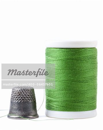 Single spool with green thread and thimble