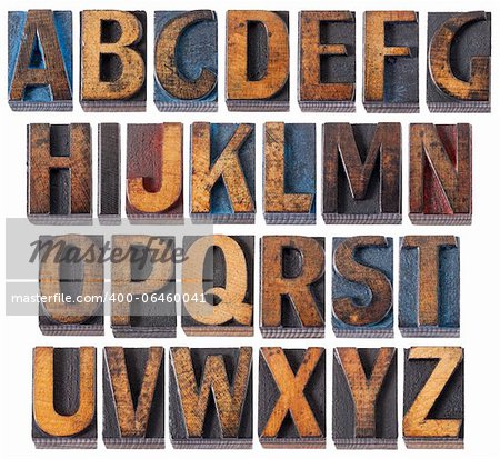 complete English alphabet - collage of 26 isolated vintage wood letterpress printing blocks, scratched and stained by blue, red and black ink