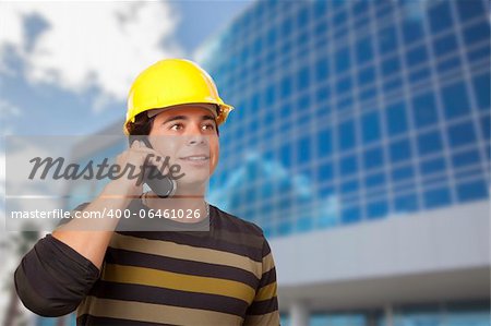 Handsome Hispanic Male Contractor on Cell Phone in Front of Corporate Building.