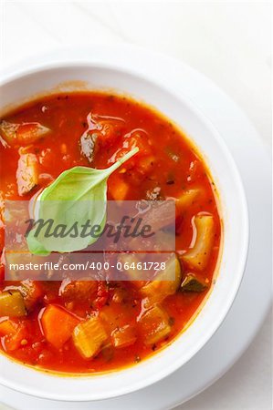 Homemade delicious minestrone soup with mozzarella and basil