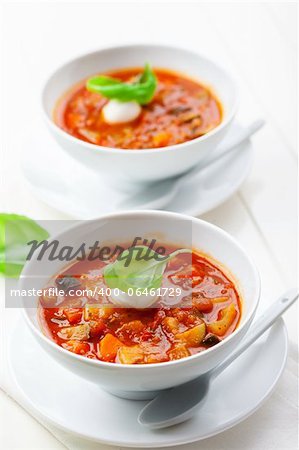 Homemade delicious minestrone soup with mozzarella and basil
