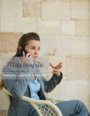 Concerned business woman speaking mobile phone