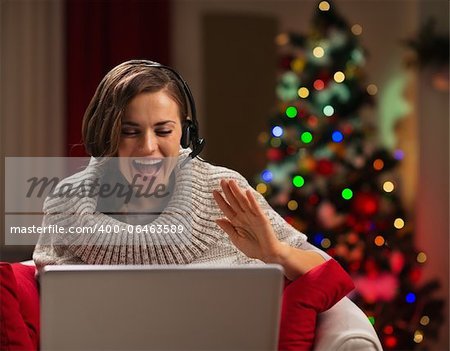 Happy young woman having Christmas video chat with family