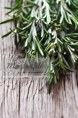 Bunch of fresh rosemary on a wooden background,