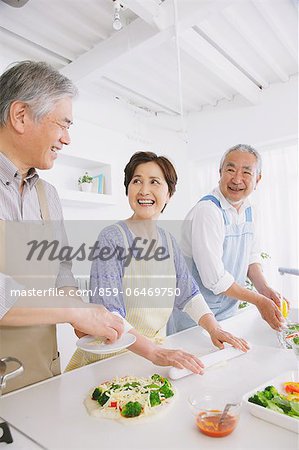 Three senior adult people attending a cooking class in an open kitchen