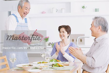 Three senior adult people eating together at an home party