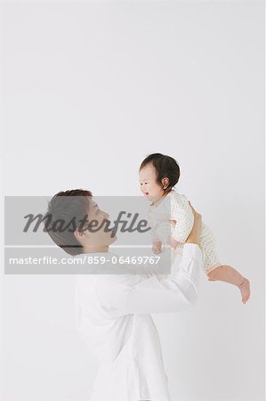 Father lifting his son and smiling