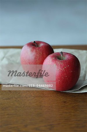 Two red apples on a wooden table Two red apples on a wooden table