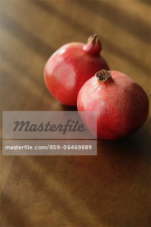 Two pomegranates on a wooden table