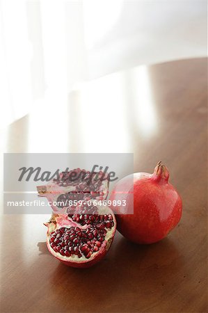 Two pomegranates on a wooden table