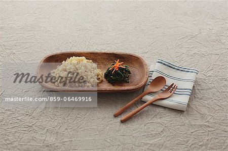 Brown rice and wooden cutlery on a tablecloth