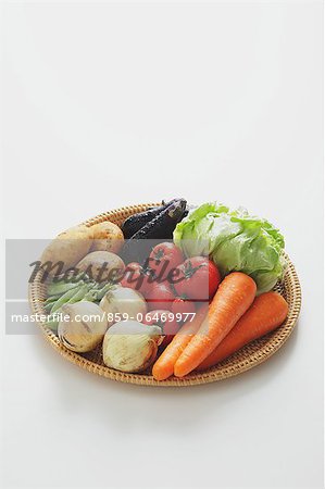 Mixed vegetables in a wooden basket on the table