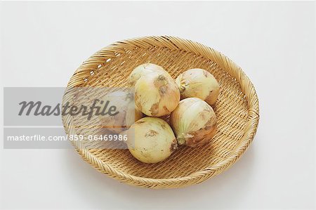 Fresh onions in a wooden basket on a table