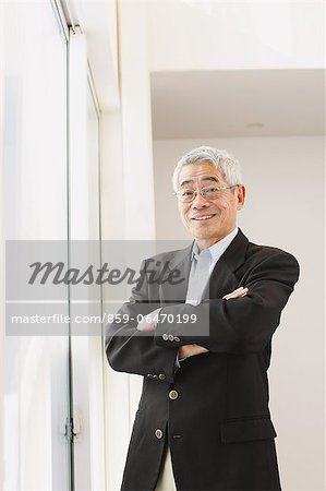 Senior adult man smiling at camera by the window