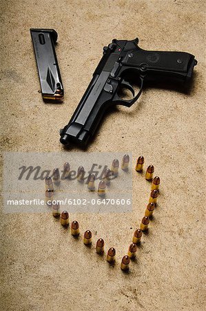 A gun and ammunition formed into a heart.
