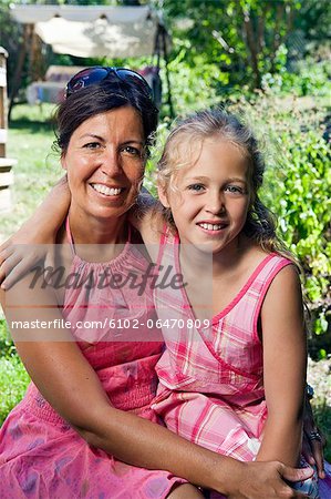 Portrait of mother with daughter in garden