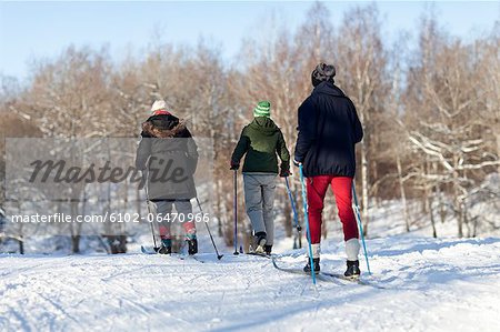 Three people cross country skiing