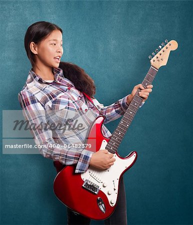 Asian girl playing the guitar and singing the song