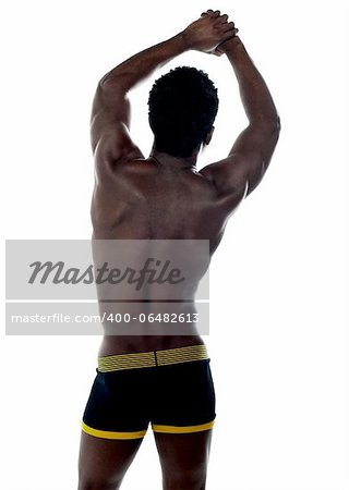 Shirtless african fit guy. Back pose. Arms up showing muscles