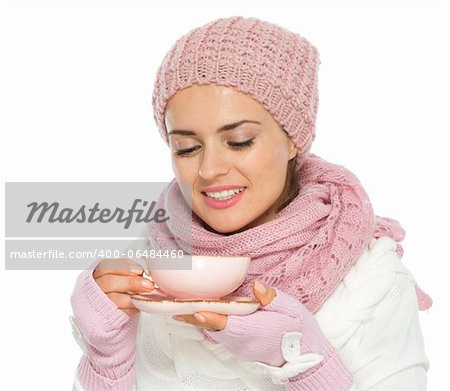 Happy young woman in knit winter clothing enjoying cup of hot tea