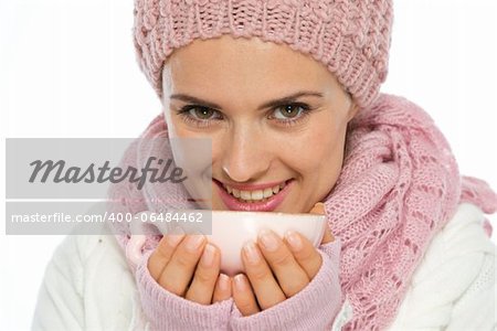 Smiling young woman in knit winter clothing holding cup of hot tea