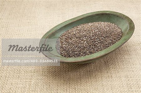 chia seeds in a rustic oval wood bowl against canvas