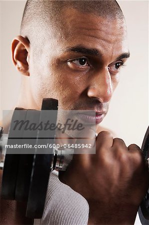 Man Lifting Weights in Studio with White Background