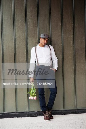 Man Leaning Against Wall Holding Flowers, Mannheim, Baden-Wurttemberg, Germany