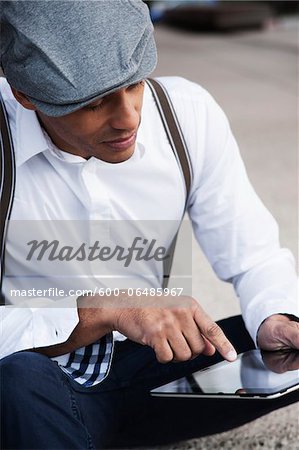 Portrait of Man Sitting on the Ground Using a Tablet, Mannheim, Baden-Wurttemberg, Germany