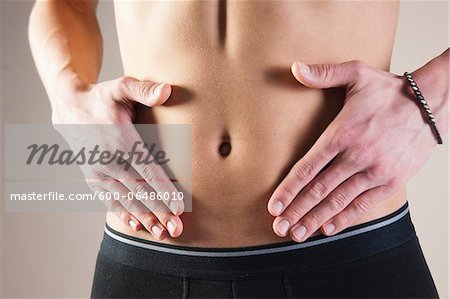 Close-up of Young Man in Underwear Touching Stomach in Studio