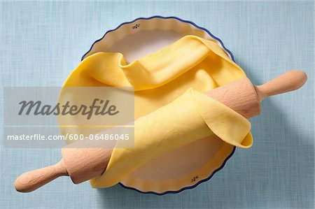 Overhead View of Pie Crust in Pie Plate and Rolling Pin on Blue Background, Studio Shot